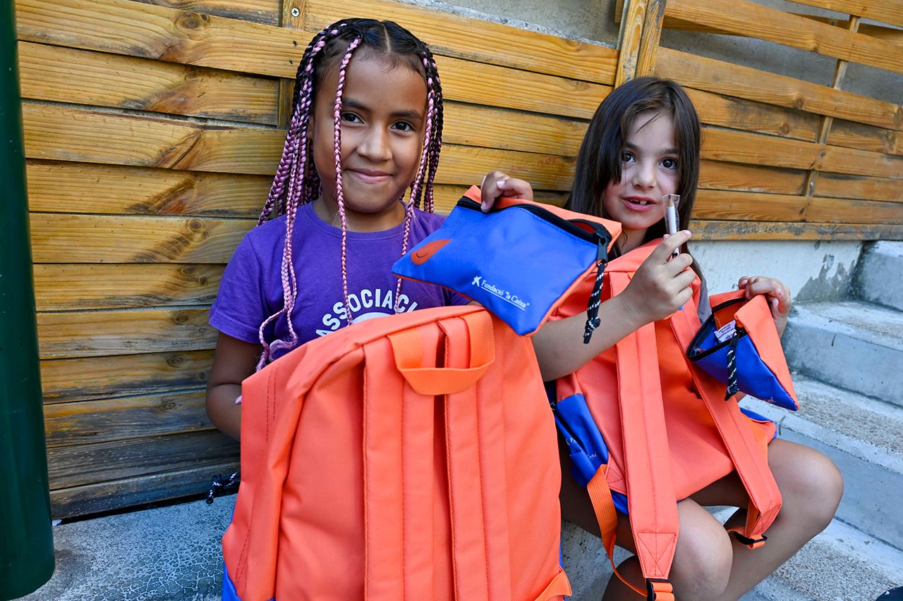 Dos niñas usuarias del programa CaixaProinfancia con su nuevo material escolar. © Fundación ”la Caixa”